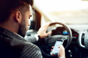 man looking at his phone while driving