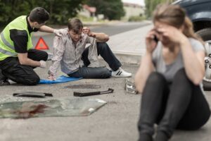 car accident victims sitting on the road