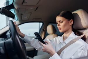 female driver distracted by his phone