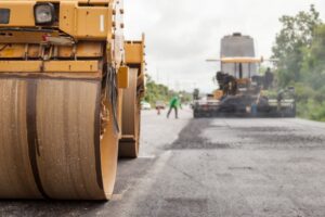 Road construction works with roller compactor machine and asphalt finisher