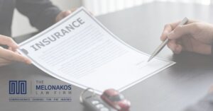 Injured driver reviewing car accident settlement paperwork with a calendar on the desk