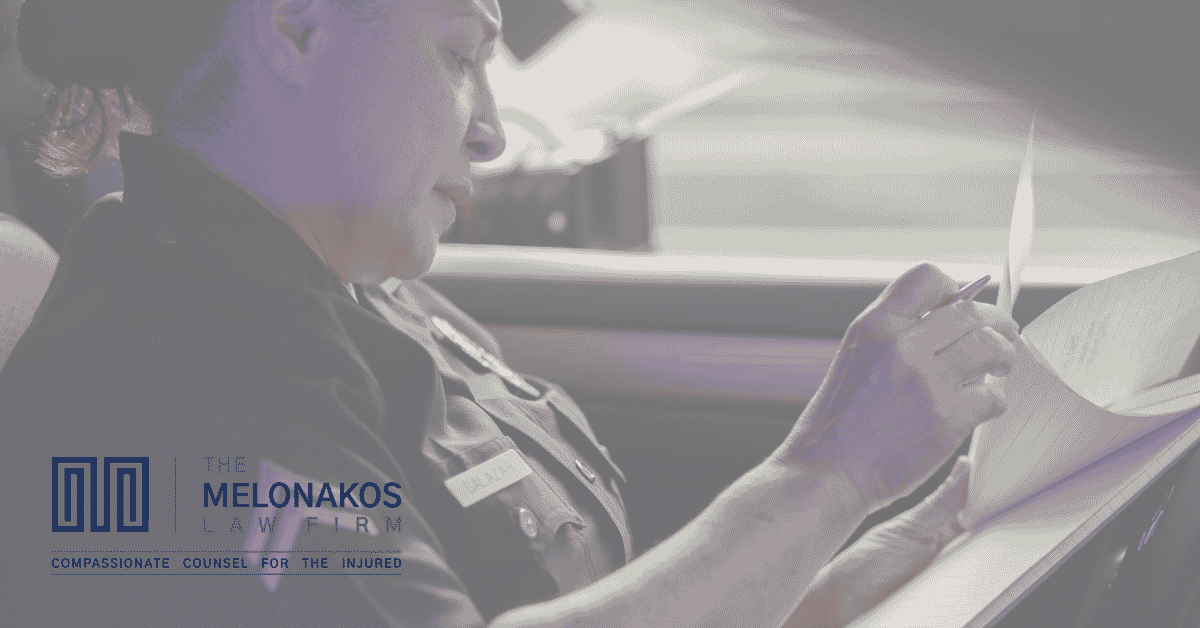 Police officer filling out a car accident report at a crash scene in Greenville
